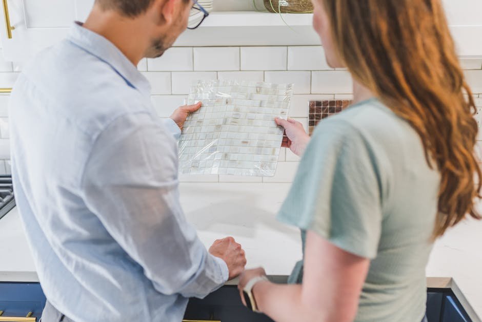 A man and woman selecting tile designs for a kitchen remodeling project.